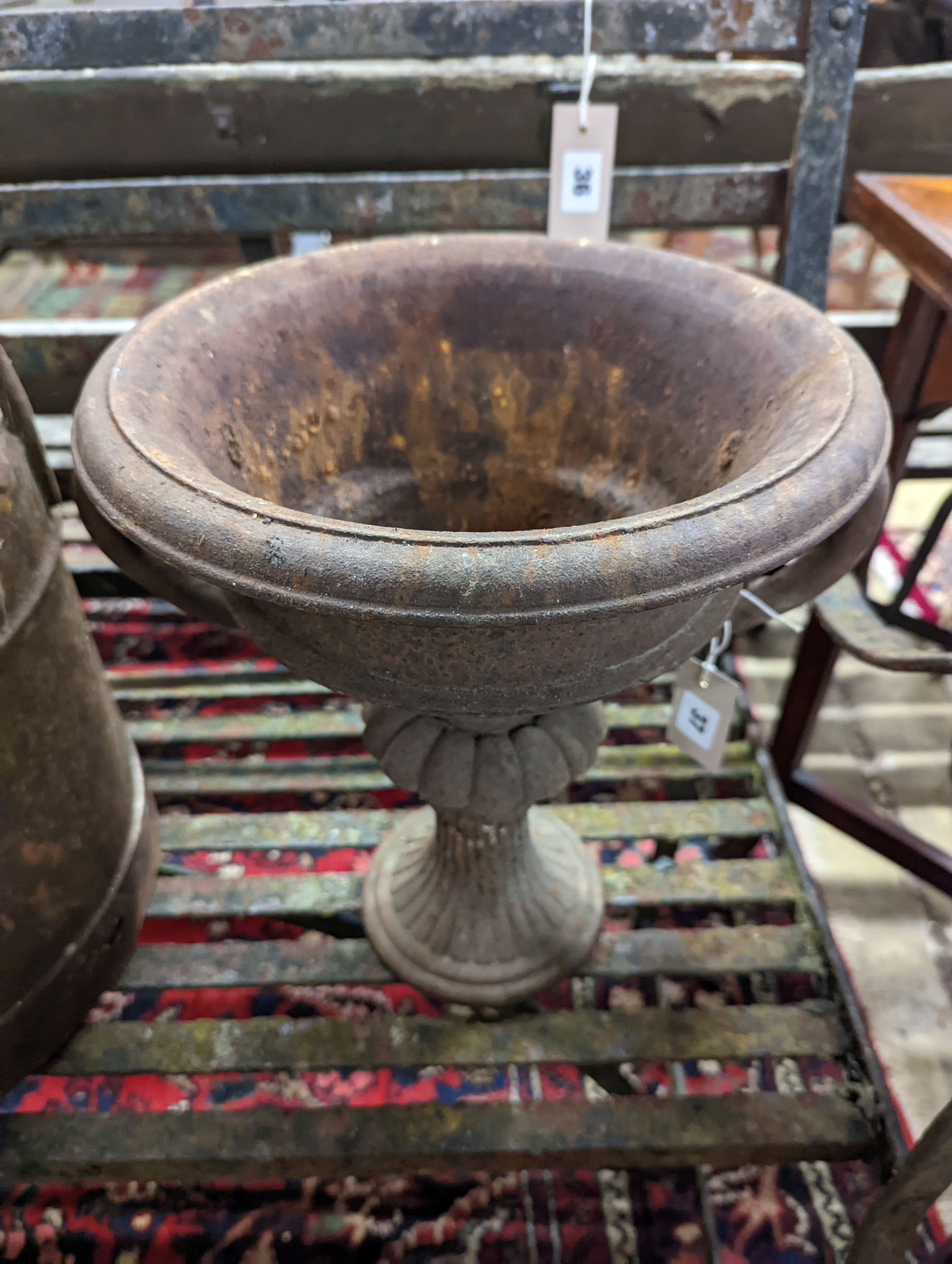 A pair of circular cast iron campana urns, diameter 29cm, height 35cm together with an iron milk churn